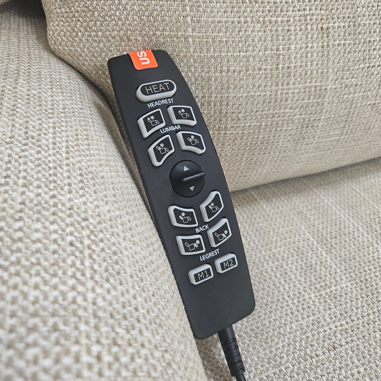 Remote control with buttons on a beige fabric surface