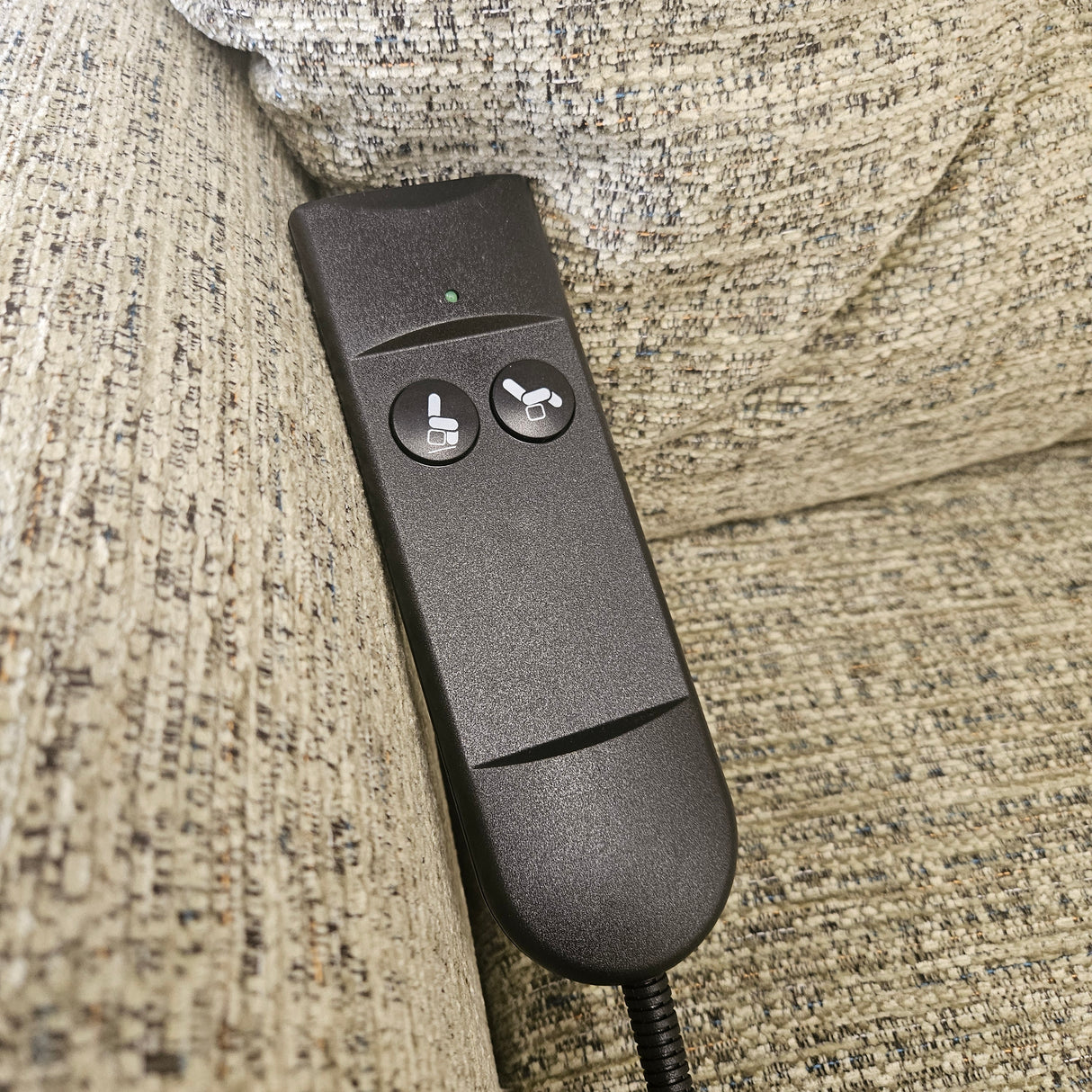 Black remote control on a textured fabric surface