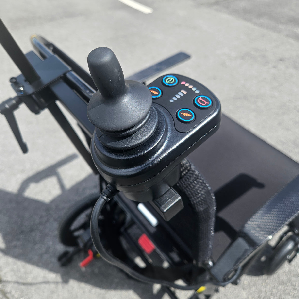 Close-up of a control handle with buttons on a powerchair.