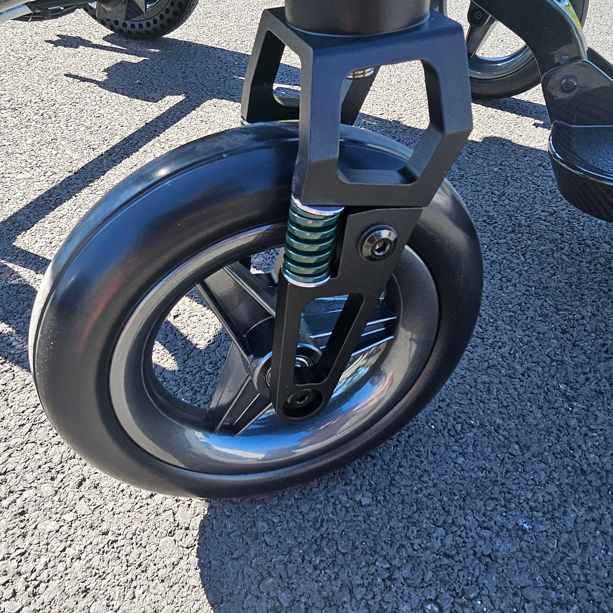 Close-up of a wheel and suspension fork on a powerchair