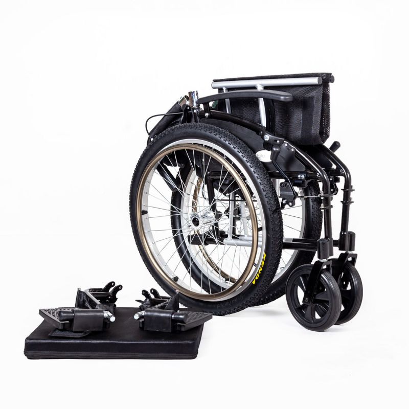 Folded collapsible wheelchair with thick tyres and detachable footrests displayed on a white background.