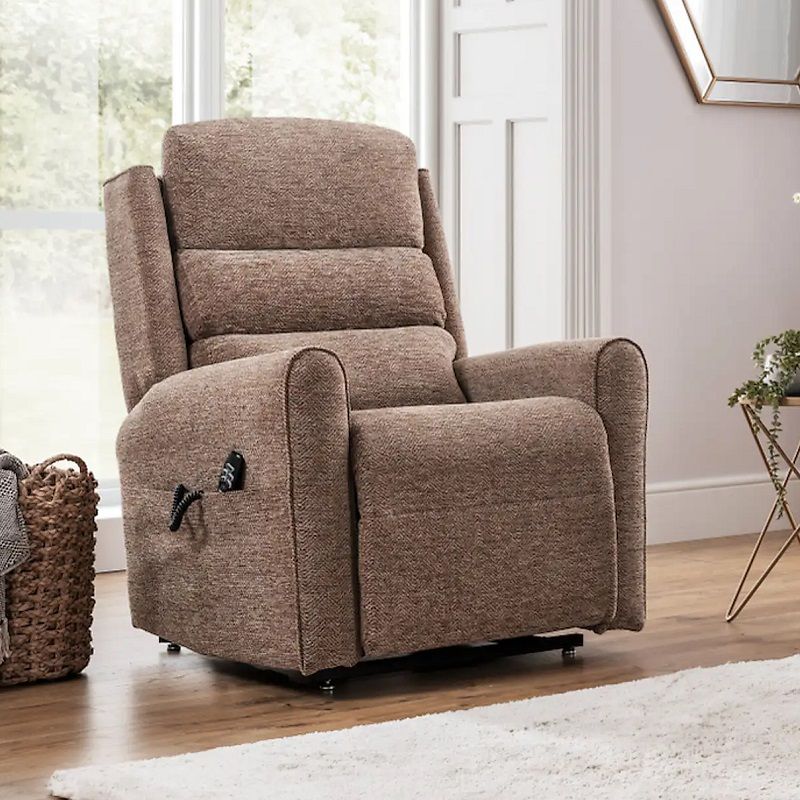 Comfortable fabric recliner chair in a neutral brown tone, featuring plush cushioning and remote-controlled reclining, placed in a modern living room with wooden flooring and natural light.