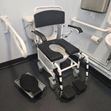 Attendant controlled wheeled shower commode chair