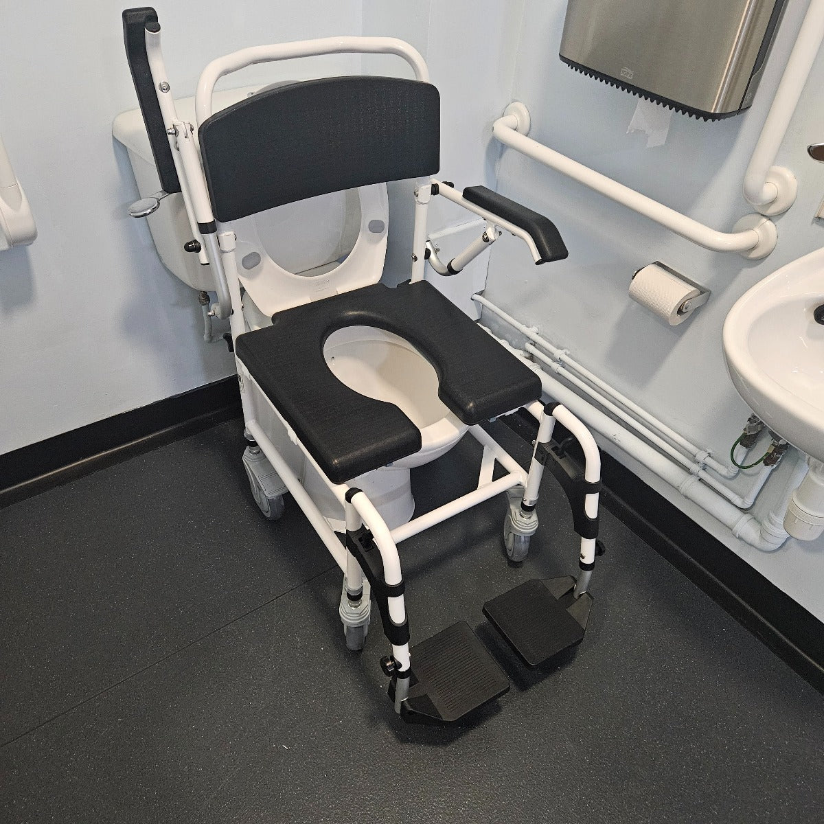 Attendant controlled wheeled shower commode chair