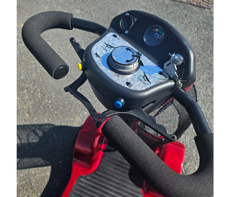 Close-up of a scooter handlebar with control panel on a pavement background