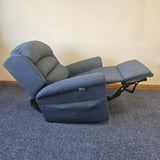 Blue recliner chair with armrests and footrest on a carpeted floor.