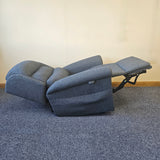 Blue recliner sofa on a carpeted floor with a plain wall background