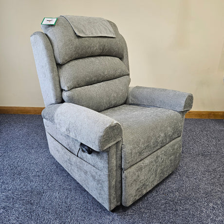 Gray recliner chair on a carpeted floor with a beige wall in the background