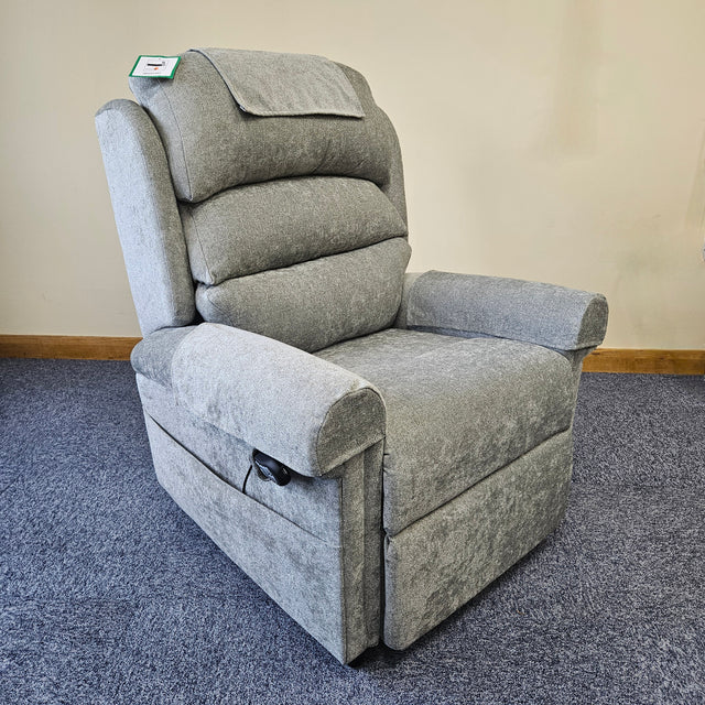 Gray recliner chair on a carpeted floor with a beige wall in the background