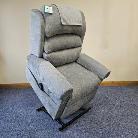 Gray recliner chair on a blue carpet with a beige wall background