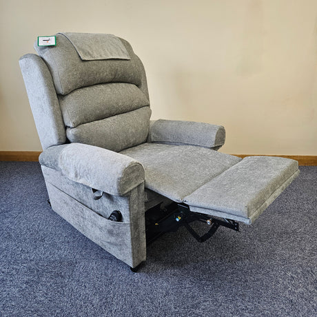 Gray recliner chair on a carpeted floor with a plain wall background