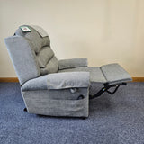 Gray recliner chair on a blue carpet with a beige wall background