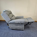 Gray recliner chair on a blue carpet with a beige wall background