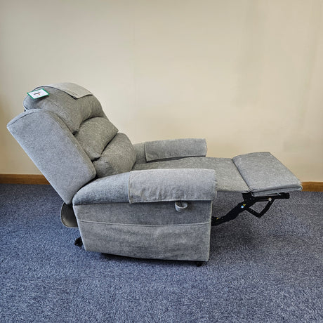 Gray recliner chair on a blue carpet with a beige wall background