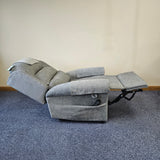 Gray recliner chair on a blue carpeted floor with a beige wall background