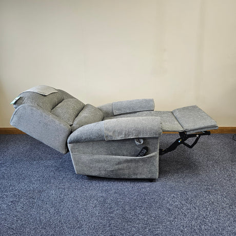 Gray recliner chair on a blue carpeted floor with a beige wall background