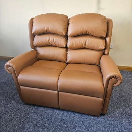 Brown leather sofa on a blue carpet with a white wall background