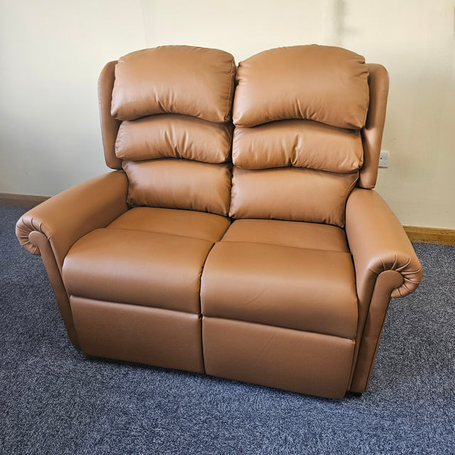 Brown leather sofa on a blue carpet with a white wall background