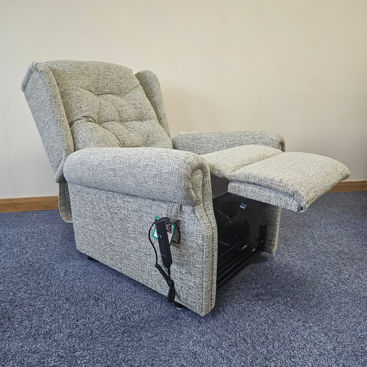 Gray recliner chair with armrests on a carpeted floor.