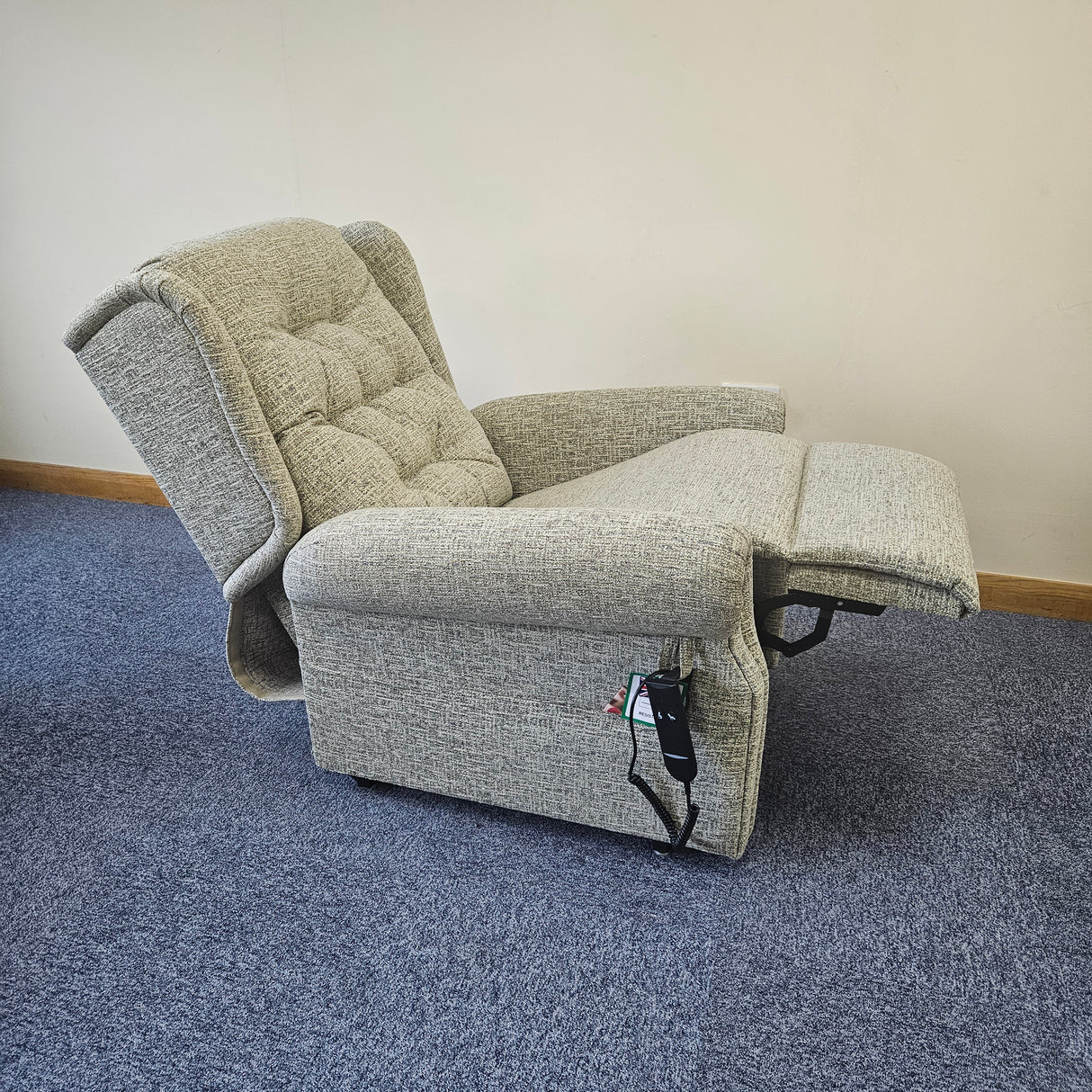 Gray riser recliner chair on a blue carpet