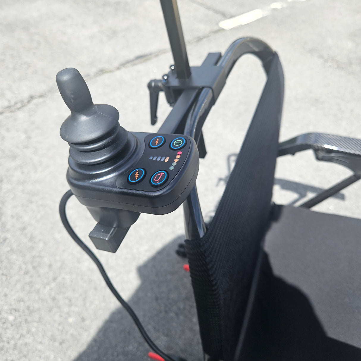 Control panel with buttons and joystick on a chair, likely for adjusting settings and movement.