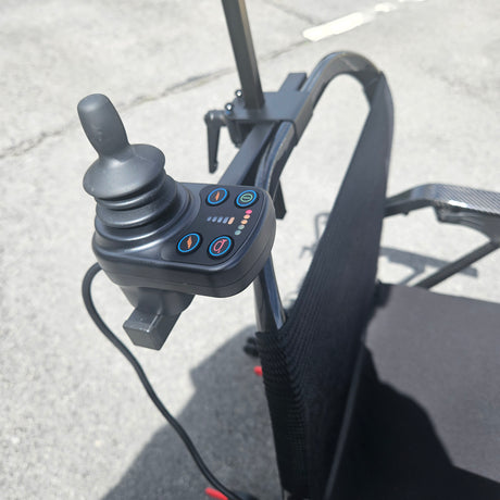 Control panel with buttons and joystick on a chair, likely for adjusting settings and movement.