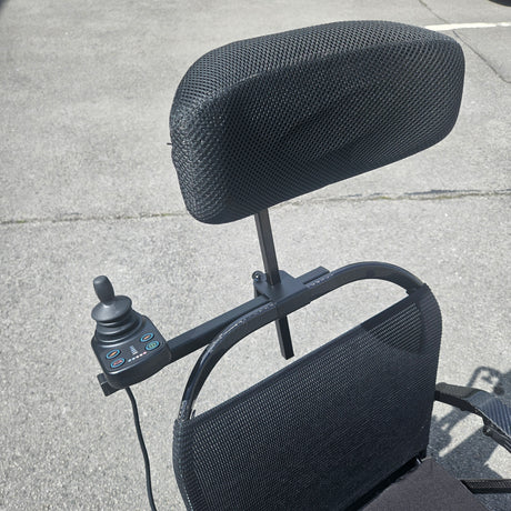 Black mesh chair with control panel on a concrete surface