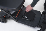 Close-up of a hand interacting with a black scooter battery on a white background.