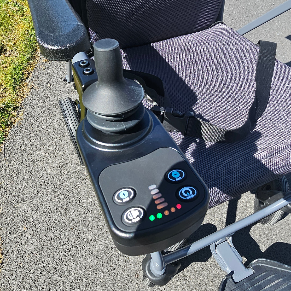 Close-up of a power wheelchair control panel with buttons and display