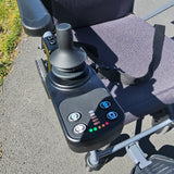 Close-up of a power wheelchair control panel with buttons and display