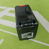 Black battery pack on a green surface 