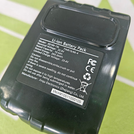 Black lithium battery pack with labels on a green background