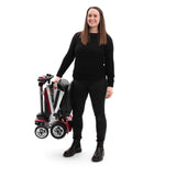 Person holding a folded mobility scooter on a white background