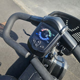 Close-up of a mobility scooter handlebar with control panel on a road