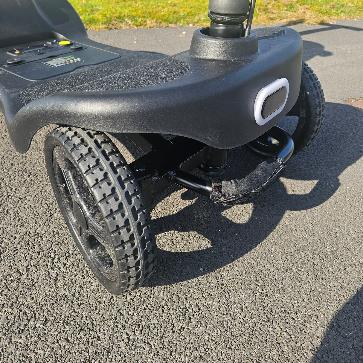 Close-up of a scooter wheel and handle on a concrete surface