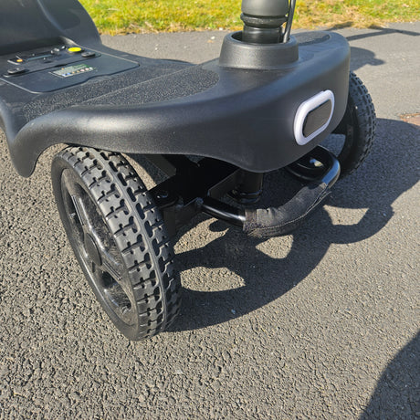 Close-up of a scooter wheel and handle on a concrete surface