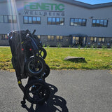 Black scooter in front of a building with 'Fenetic Wellbeing' branding.