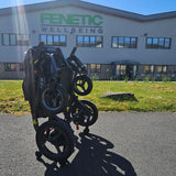 Folded electric wheelchair on a driveway with a building in the background