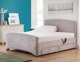 Gray upholstered bed in a room with a blue wall and window.