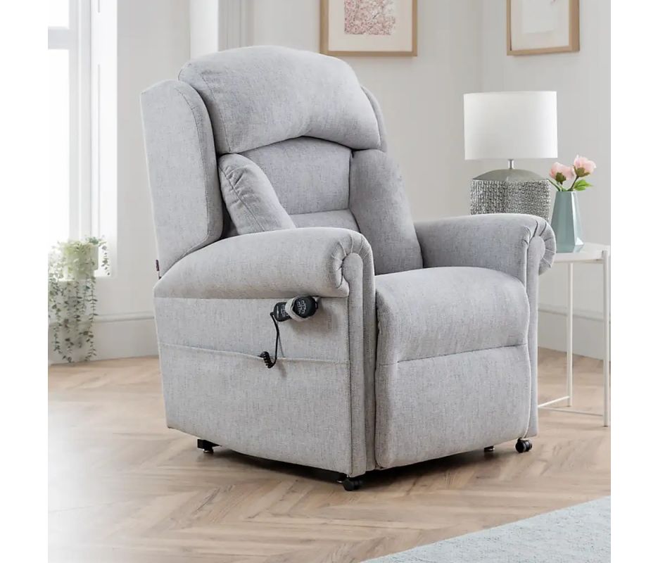 Gray recliner chair in a living room setting with light wood flooring and white walls.