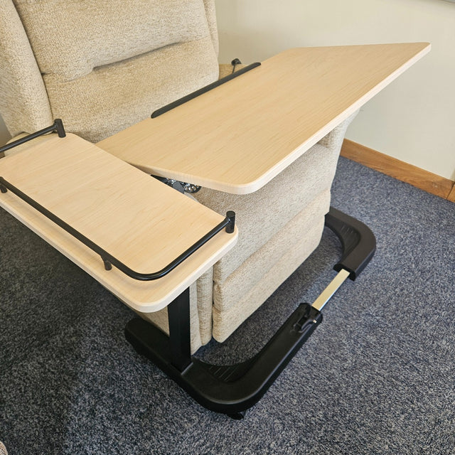 Portable lap desk attached to a recliner chair on a carpeted floor.