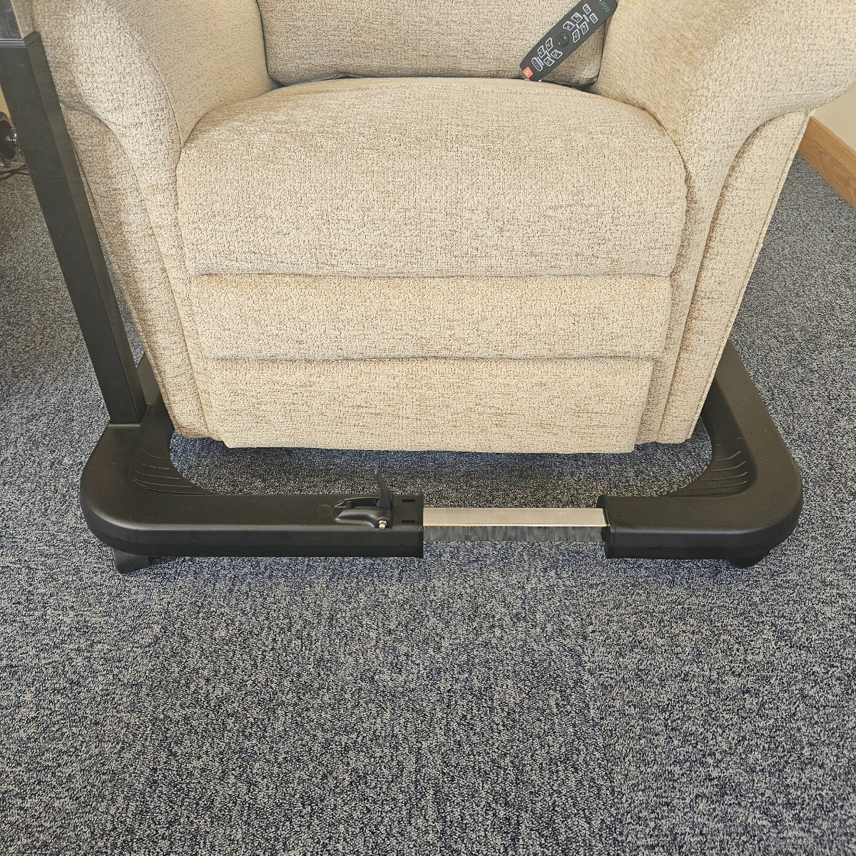Beige recliner chair with a footrest on a gray carpet