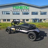 Folded mobility scooter on a paved surface with a building in the background