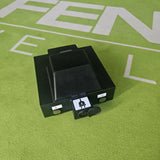 Black electrical component on a green surface with text