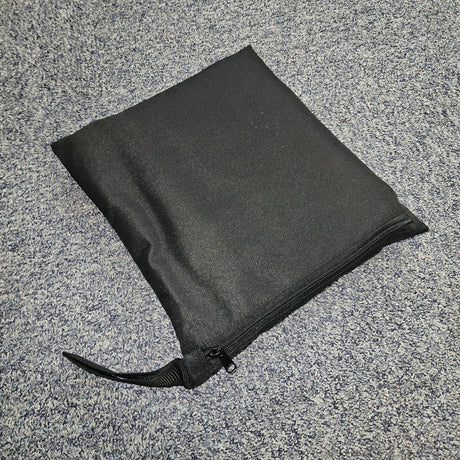 Black zip bag on a grey textured surface