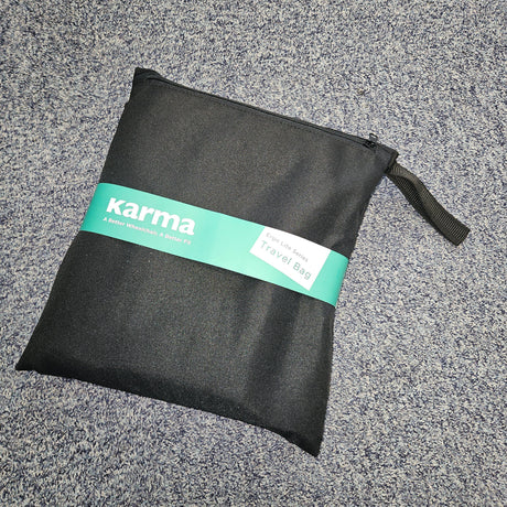 Black pouch with a green 'karma' label on a gray textured surface