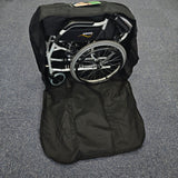 Foldable wheelchair inside a black carrying bag on a gray floor.