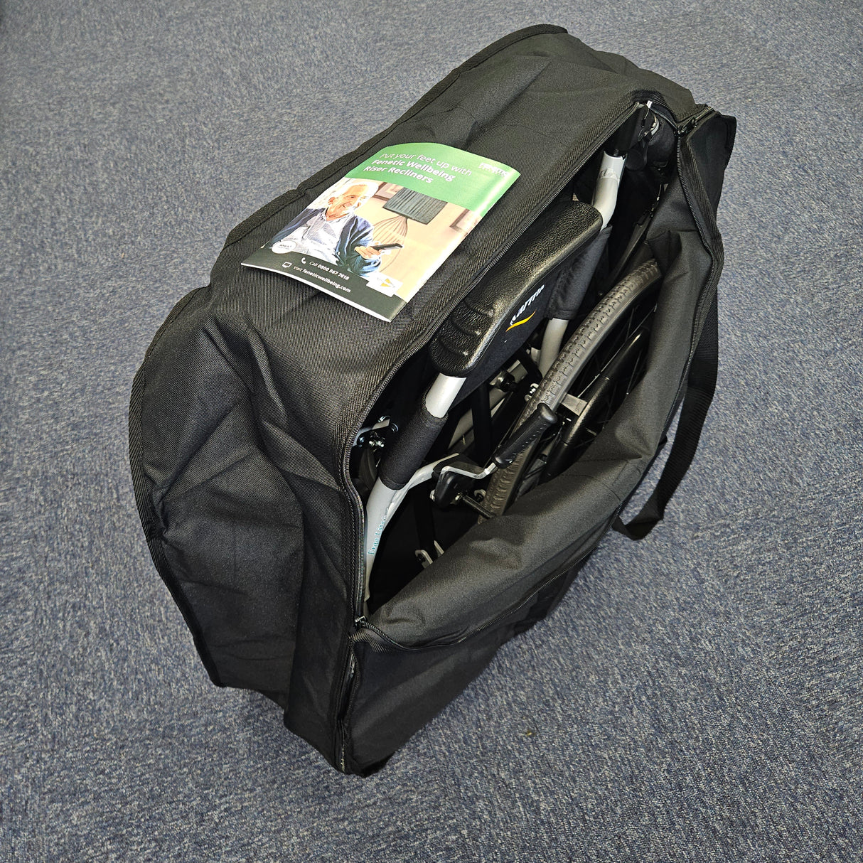 Black duffel bag with a folded chair inside on a gray surface