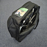 Black duffel bag with a folded chair inside on a gray surface