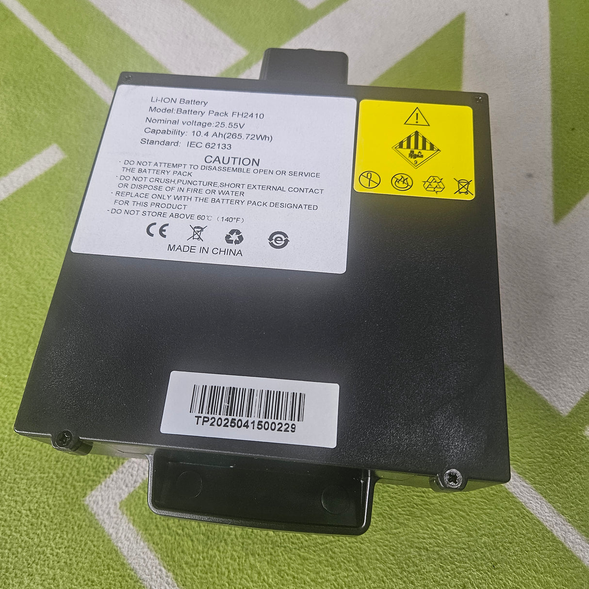 Black battery pack with labels on a green background